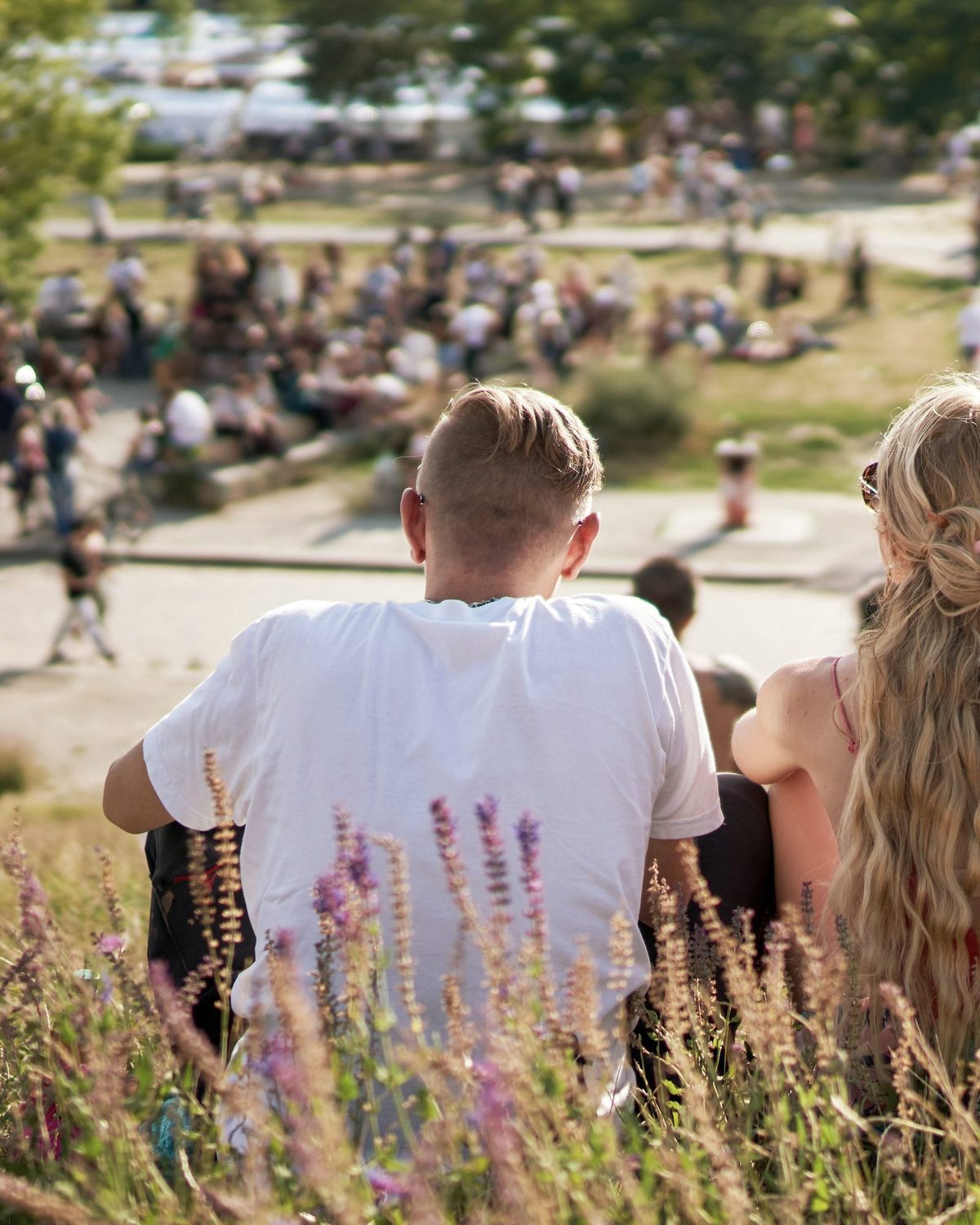 Zwei Menschen sitzen auf einer Sommerwiese